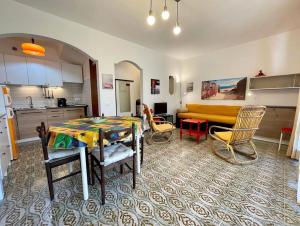 a kitchen and a living room with a table and chairs at Lovely villa with a private garden in Porto Santa Margherita di Caorle