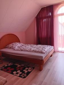 a bedroom with a bed in a room with a window at Mazsola Vendégház in Tamási