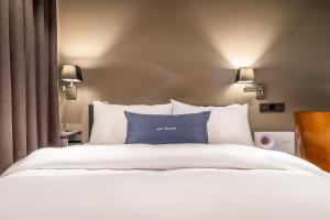 a bedroom with a white bed with blue pillows at Chocolate Hotel Seongnam in Seongnam +24 photos