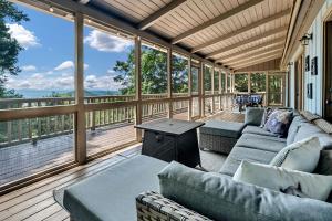 a screened in porch with couches and a table at Cozy Walnut Mountain Cabin with Hot Tub & Views in Ellijay