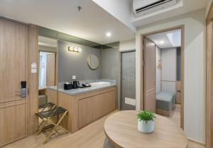 a bathroom with a sink and a toilet and a table at GOLDEN TULIP ESSENTIAL PIK2 JAKARTA in Tangerang