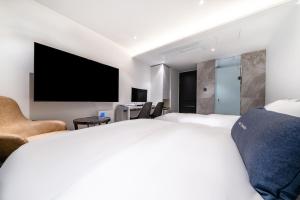 a hotel room with a large bed and a flat screen tv at Chocolate Hotel Seongnam in Seongnam