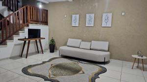 a living room with a couch and a staircase at Casa shanti living in Dourados