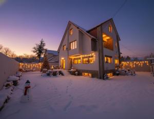 a house with christmas lights in the snow at Villa Lumiere-Luxury Retreat with Private Spa and Garden in Ifrane