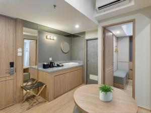 a bathroom with a sink and a table in a room at GOLDEN TULIP ESSENTIAL PIK2 JAKARTA in Tangerang