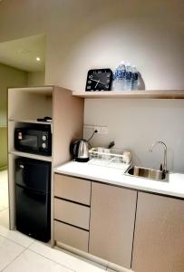 a small kitchen with a sink and a stove at Seaview Cosy BS Homestay in Kota Kinabalu