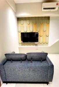 a living room with a couch and a flat screen tv at Seaview Cosy BS Homestay in Kota Kinabalu