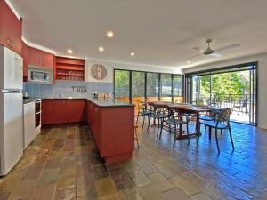 a kitchen with red cabinets and a table with chairs at A Beach Affair in Amity Point