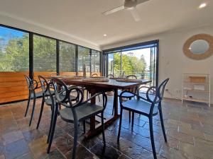 a dining room with a wooden table and chairs at A Beach Affair in Amity Point +10 photos
