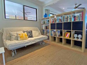 sala de estar con sofá y estanterías en A Amity Beach Baby, en Amity Point
