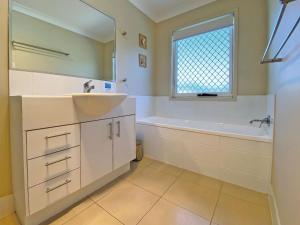 a bathroom with a sink and a tub and a mirror at FLIP FLOP INN in Amity Point +8 photos
