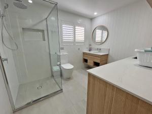 a bathroom with a shower and a toilet and a sink at Flinders Breeze in Amity Point +16 photos