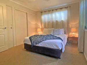 Un dormitorio con una cama grande y una ventana. en Amity Seaside, en Amity Point