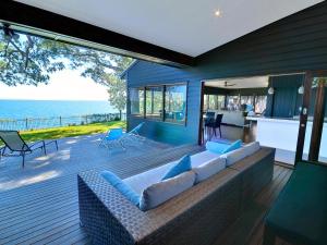 a couch on a deck with a view of the ocean at Dolphins at Sunset in Amity Point