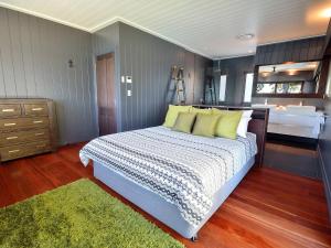 a bedroom with a bed and a bathroom with a sink at Dolphins at Sunset in Amity Point