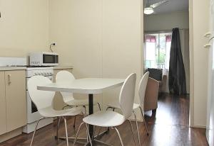 Una cocina blanca con una mesa y sillas blancas. en Berrimilla, en Amity Point