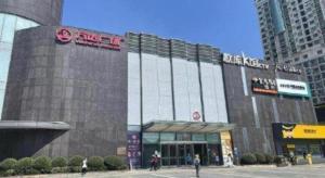 a large building with people walking in front of it at Xana Hotelle Wuhan Lingjiao Lake Wanda Plaza Branch in Wuhan