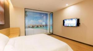 長沙市にあるIU Hotel Changsha Railway Station Branchのベッドと薄型テレビのある寝室