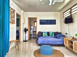 モーレア島にあるCharmant logement avec accès privé à la plageのソファとテーブルのあるリビングルーム