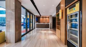 a hallway of a store with glass doors and a kitchen at IU Hotel Kunming Jinma Bijifang Joy City in Kunming