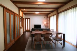 a dining room with a table and chairs and a couch at Shinyashiki Guest House - Vacation STAY 78619v in Kumamoto