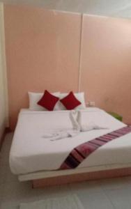 Cette chambre comprend un lit avec des oreillers rouges et blancs. dans l'établissement Lanta white sand beach guesthouse, à Phra Ae beach