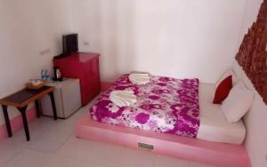 - une petite chambre avec un lit et une couverture violette dans l'établissement Lanta white sand beach guesthouse, à Phra Ae beach 4 autres photos