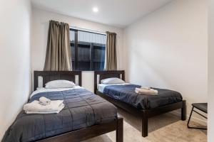 a bedroom with two beds and a window at Puhinui House in Warkworth +11 photos