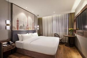 a large white bed in a hotel room at Yiwu Manxin Hotel in Yiwu