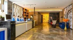 a lobby of a hotel with people standing at a counter at Echarm Hotel Guilin Zhongshan Zhong Road Liangjiang Sihu in Guilin