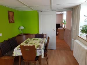 a dining room with a table and a green wall at Gästehaus Futterer in Teningen