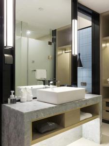 長沙市にあるEcharm Hotel Changsha Gaoqiaoの洗面台と大きな鏡のあるバスルーム