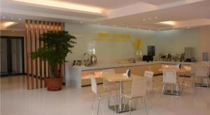 a restaurant with tables and white chairs and a counter at City Comfort Inn zhongshan Lihe Square Walmart in Zhongshan