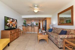 Una sala de estar con un sofá y una cocina. en Kahana Reef 117 · KR 117 Renovated OceanFront 1BD w Ocean Views, en Kahana