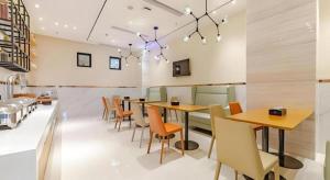 a dining room with wooden tables and chairs at City Comfort Inn Chengdu Southwest University of Finance and Economics Wansheng Metro Station in Chengdu