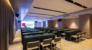 a room with green tables and chairs and a screen at Echarm Hotel Nanning Dongge Macun Metro Station in Nanning