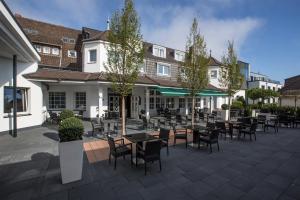 a patio with tables and chairs in front of a building at Hotel & Restaurant Schönau in Peine