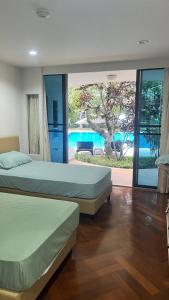 two beds in a bedroom with a view of a pool at Beachfront two bedroom apartment in Ban Nong Chaeng +18 photos