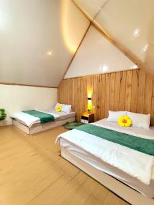 a bedroom with two beds in a attic at Dieng Hebat Villa & Glamping in Dieng