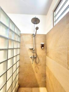 a shower in a bathroom with a glass wall at Une pause au soleil et proche de la mer in Moorea +19 photos