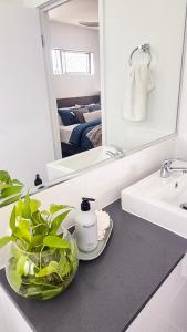 un baño con lavabo y espejo en Coastal Calm, en Kawana Waters