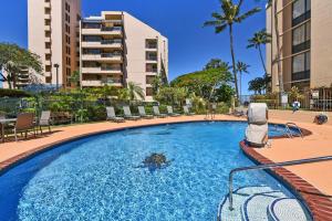 a large swimming pool with chairs and a building at Valley Isle 401 · VI 401 Remodeled OceanFront Condo w Ocean View in Kahana