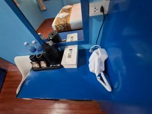 Una mesa azul con un control remoto de Wii en una habitación. en Wow-Guesthouse soi 19, en Bangkok