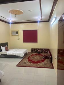 Habitación con cama y alfombra en el suelo en شقق لافندر, en Sūq ath Thalut