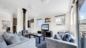 a living room with two couches and a tv at Cool Runnings in Dinner Plain