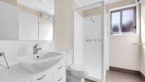 a white bathroom with a sink and a toilet at Cool Runnings in Dinner Plain +22 photos