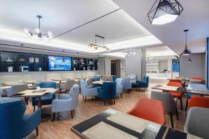 a restaurant with tables and chairs and a bar at Echarm Hotel Suzhou Shengze Oriental Extile City in Suzhou