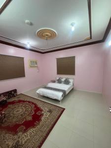 a bedroom with a bed in a room with pink walls at شقق لافندر in Sūq ath Thalut +23 photos