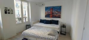 Un dormitorio con dos camas y un cuadro en la pared. en Appartement paisible, en Clichy