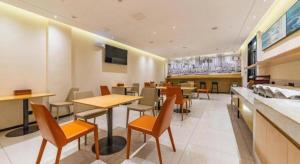 a dining room with tables and chairs in a restaurant at City Comfort Inn Wuhan Changfeng Avenue 3rd Hanxi Road in Wuhan